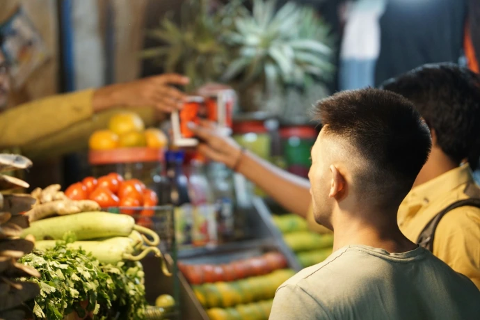 a man standing in front of a display of fruits and vegetables